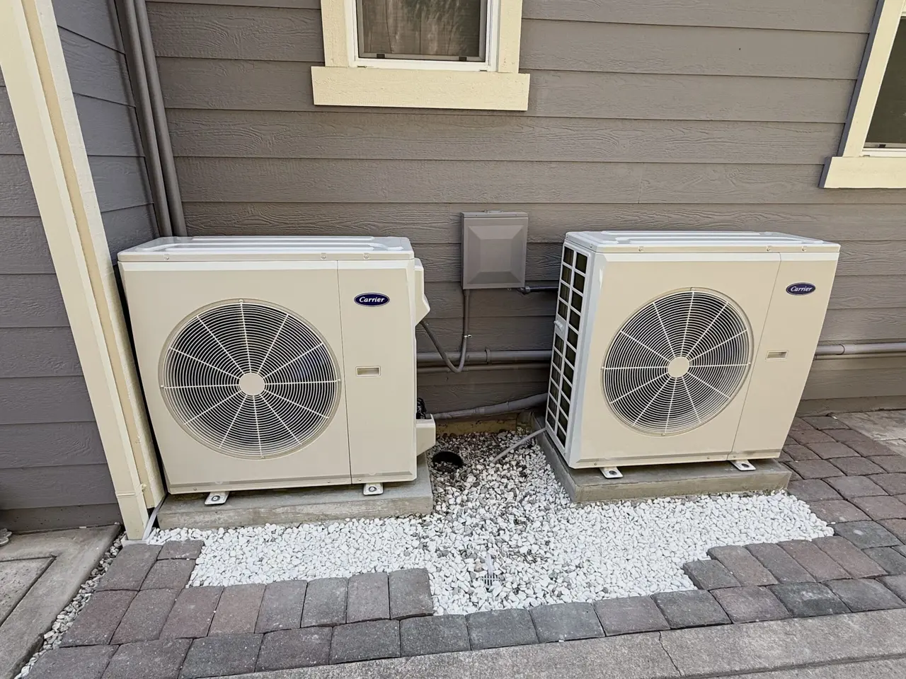 Residential heat pump outdoor unit installed beside a home